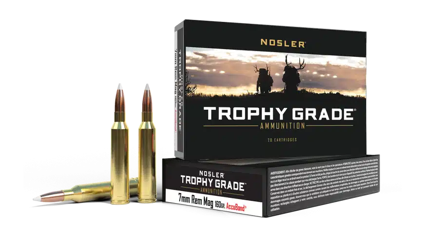 A box of Nosler Trophy Grade ammunition, featuring 7mm Rem Mag cartridges alongside two cartridges, with a scenic hunting backdrop.