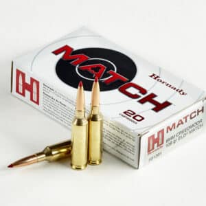 A box of Hornady Match rifle cartridges with two bullets in front of it on a white background.