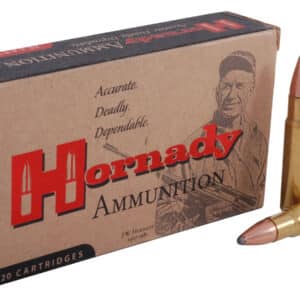 A box of Hornady ammunition with one cartridge standing and one lying down beside it.