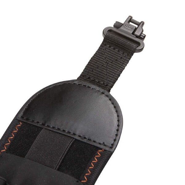 Close-up of a black padded strap with a sturdy buckle and orange stitching, designed for secure fastening.