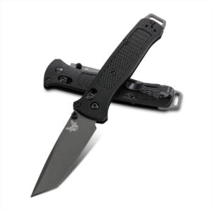 BENCHMADE BAILOUT - Two black Benchmade folding knives diagonally arranged, one with a partially visible blade and the other closed. The knives have textured handles, a pocket clip, and a visible butterfly logo on the open blade.