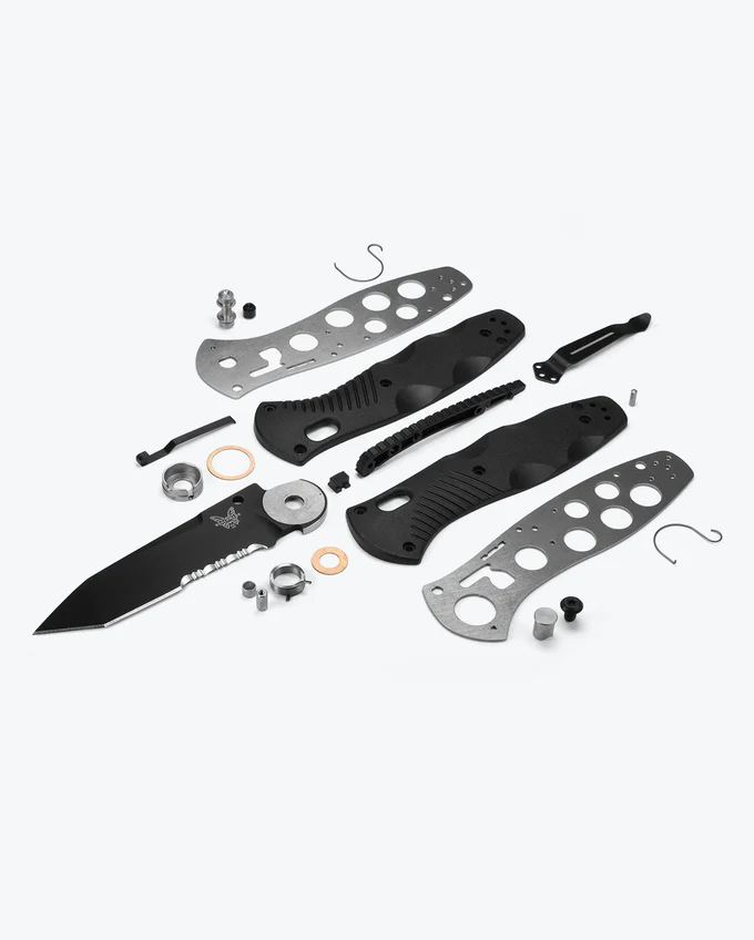 Disassembled knife components, including blade, handles, screws, and hardware, arranged neatly on a light background.
