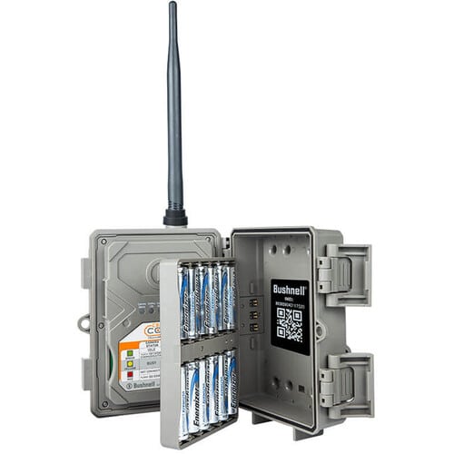 A Bushnell device with an antenna and open casing, displaying battery compartment and internal components for operation.