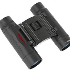 TASCO ESSENTIALS 10X25 COMPACT BINOCULAR - Close-up of compact Tasco binoculars, featuring a black body with red branding, designed for portability and outdoor use.