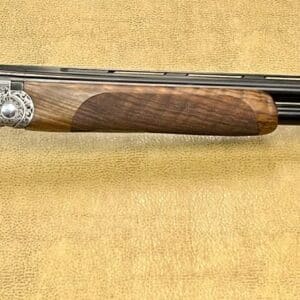 A double-barreled shotgun with intricate engravings on the metal and wooden stock.