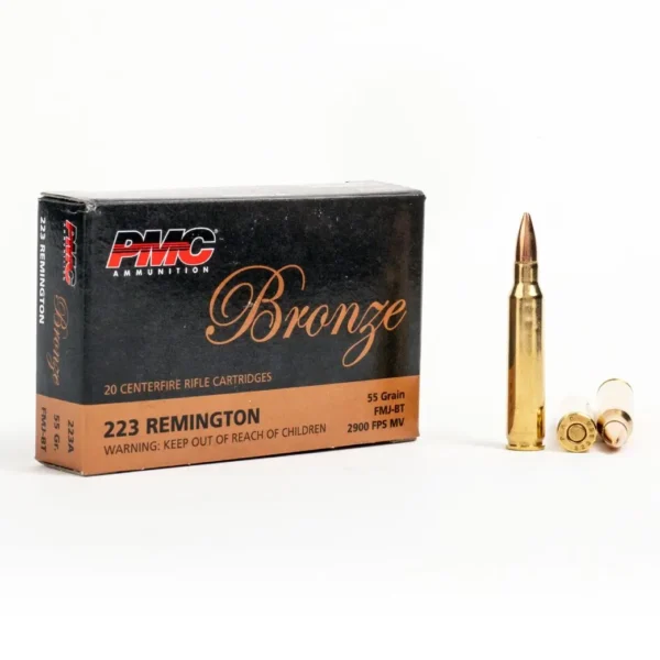 A box of PMC Bronze .223 Remington rifle cartridges next to a full bullet and casings.