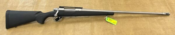 A stainless steel bolt-action rifle with a black synthetic stock and a price tag attached.