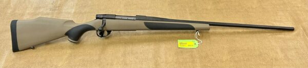 A bolt-action rifle with a beige synthetic stock and price tag displayed on a textured background.