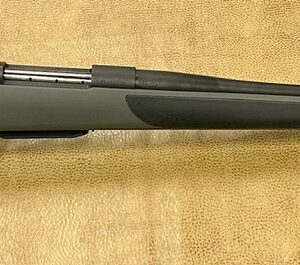 A two-toned bolt-action riffle with a price tag on a beige background.