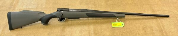 A two-toned bolt-action riffle with a price tag on a beige background.