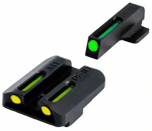 Tritium night sights for a handgun with green and yellow dots, isolated on a white background.
