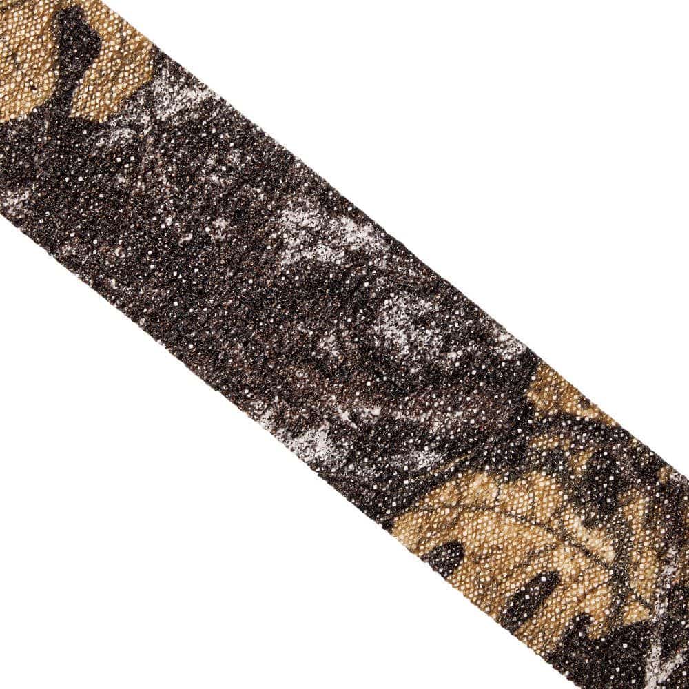 A close-up of a thin, textured fabric strip in earthy tones with a camouflage pattern showcasing browns, blacks, and subtle golds.